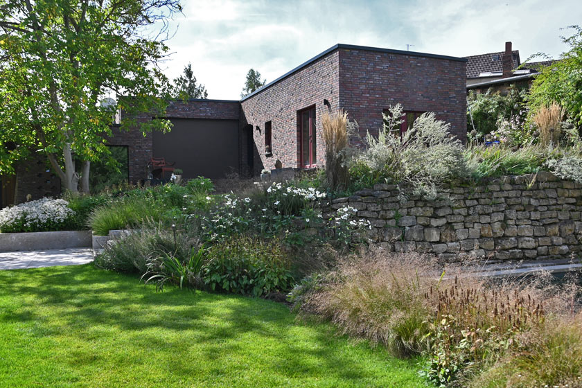 Der Übergang vom Innenhof zur wilderen Mauer­kone trifft auf das Duftband aus Tautropfengras.