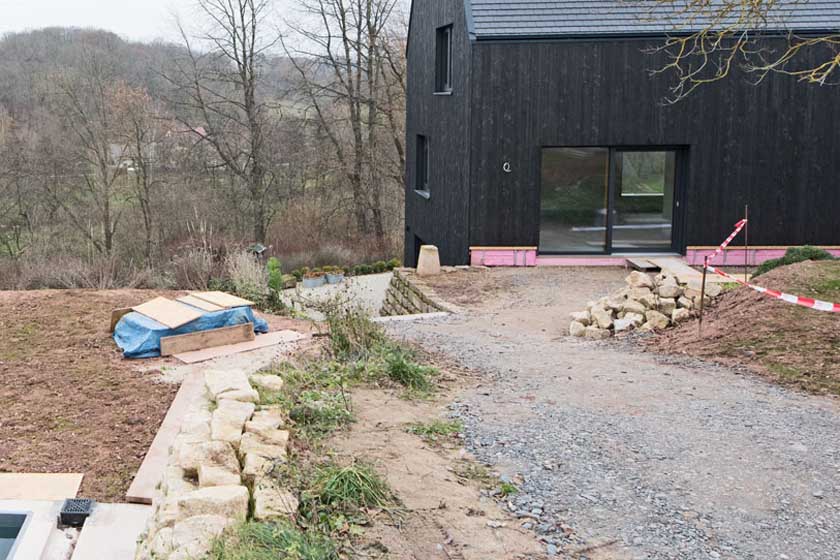 Winteraufnahme des Hauses mit zurückgeschnittener Weidenblättriger Sonnenblume im Vordergrund.